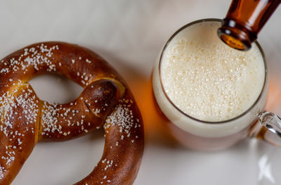 High angle view of beer and pretzel on table