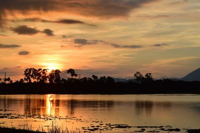 Scenic view of lake against orange sky