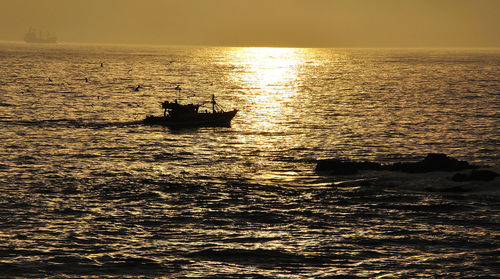 Boat in sea at sunset