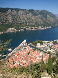 High angle view of townscape by lake against mountain