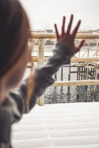 Rear view of woman standing by railing