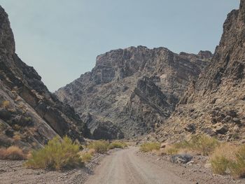Road amidst rocky mountains against sky