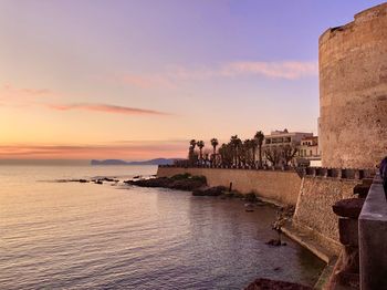 People on beach against sky during sunset