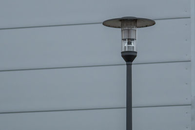 Low angle view of illuminated lamp on wall