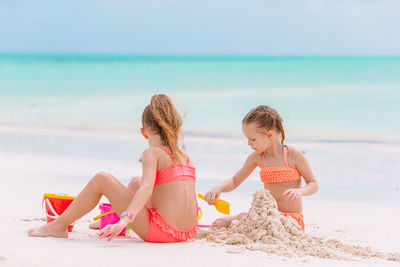 Side view of young woman sitting at beach