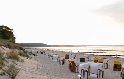 Chairs on beach against clear sky