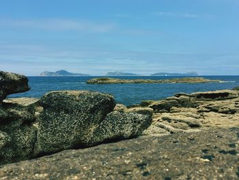 Rocks by sea at cies islands against sky