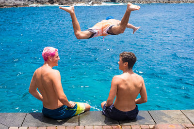 Rear view of shirtless boy in swimming pool