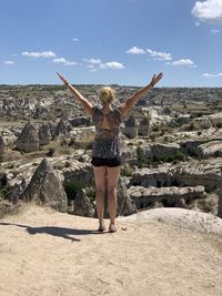 Rear view of woman standing on rock