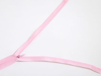 Close-up of pink zipper on white background