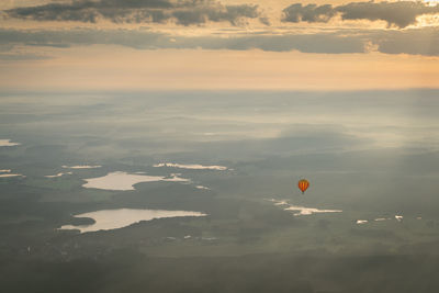 Aerial view of hot air balloon against cloudy sky