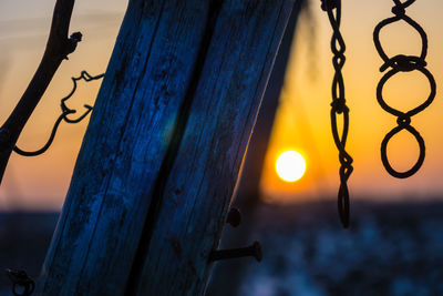 Low angle view of metal hanging over sea against sky