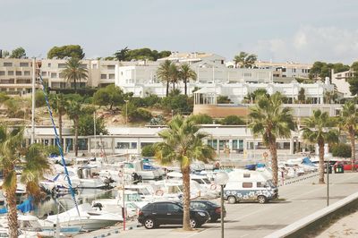 Cars on road by sea against sky in city