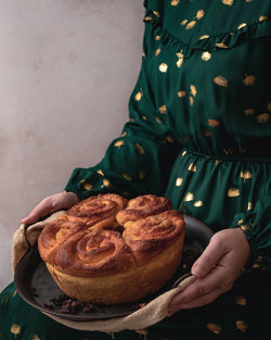 Midsection of woman holding a cake 