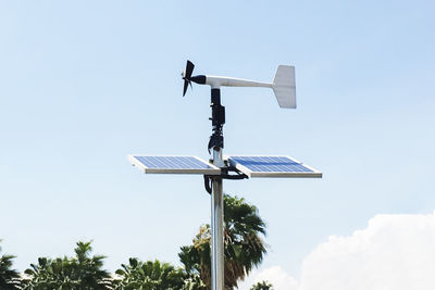 Low angle view of weather vane against sky