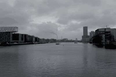 River in city against cloudy sky