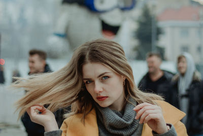 Portrait of beautiful young woman tossing hair in city