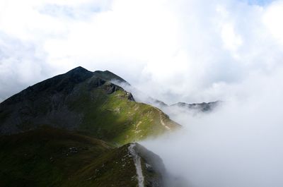Scenic view of mountains against cloudy sky