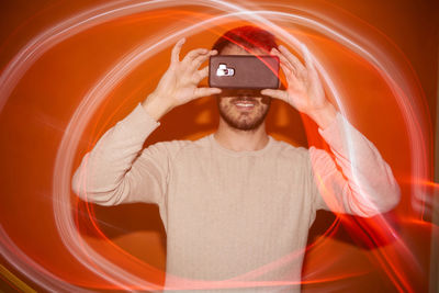 Young man with smartphone and flashes of colored light