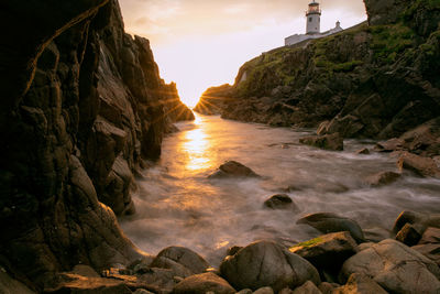 Rock formations by sea against sky