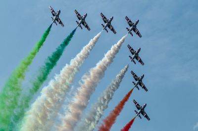 Low angle view of airplanes flying against sky