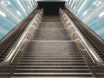 Low angle view of staircase amidst escalators at subway station