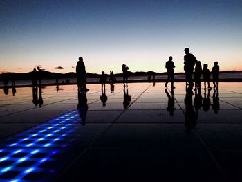 Silhouette people against clear sky at sunset - salutation to the sun in zadar croatia
