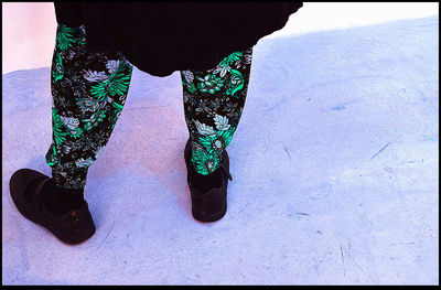 Low section of woman standing on street