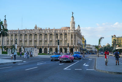 Cars on street against clear sky