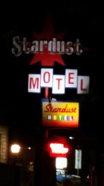 Low angle view of road sign at night