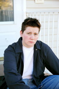 Portrait of tomboy sitting outside house