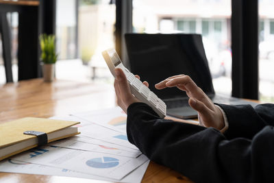 Midsection of businessman working on table