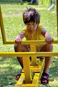 Rear view of boy sitting in park