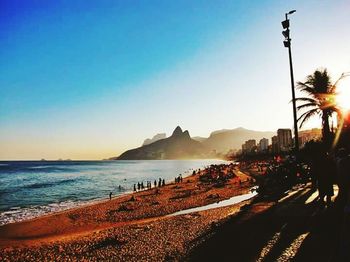 Scenic view of beach against clear sky at sunset