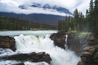 Scenic view of waterfall against sky