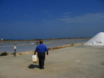 Rear view of man against salt flats