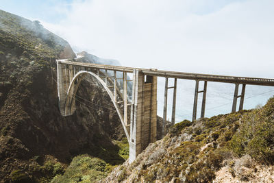 Arch bridge over river against sky