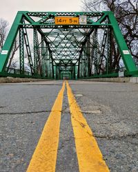 Surface level of yellow road against bridge