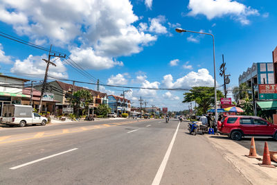 View of city street against cloudy sky