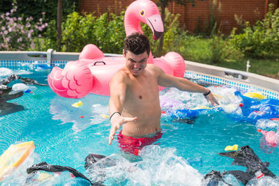 Full length of shirtless man swimming in pool