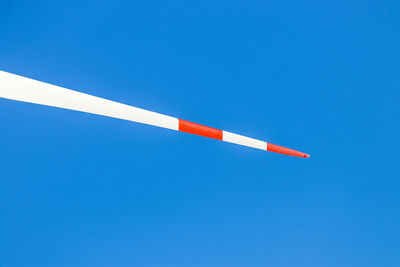 Low angle view of red flag against clear blue sky