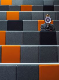 Man sitting with megaphone on chair