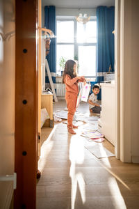 A girl among the mess and scattered sheets in the room.