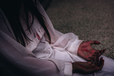 Midsection of young woman covered in blood during halloween