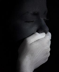 Close-up of human hand against black background