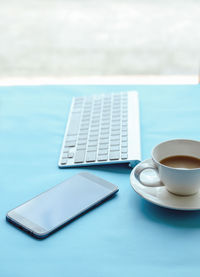 Coffee cup on table by swimming pool