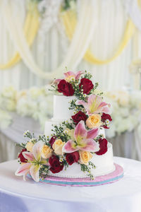 Close-up of flowers on wedding cake over table