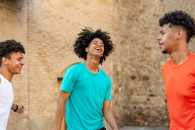 Group of afro latin male friends dancing in the street