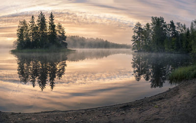 Scenic view of lake against sky at sunset