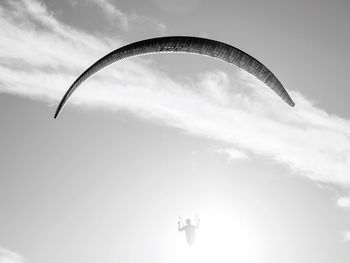 Low angle view of person paragliding against sky